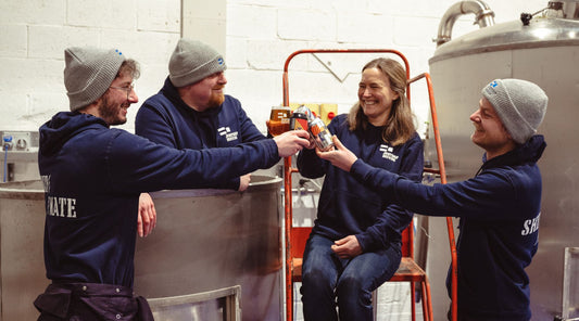 The Jump Ship team share a drink and cheers in a brewery setting