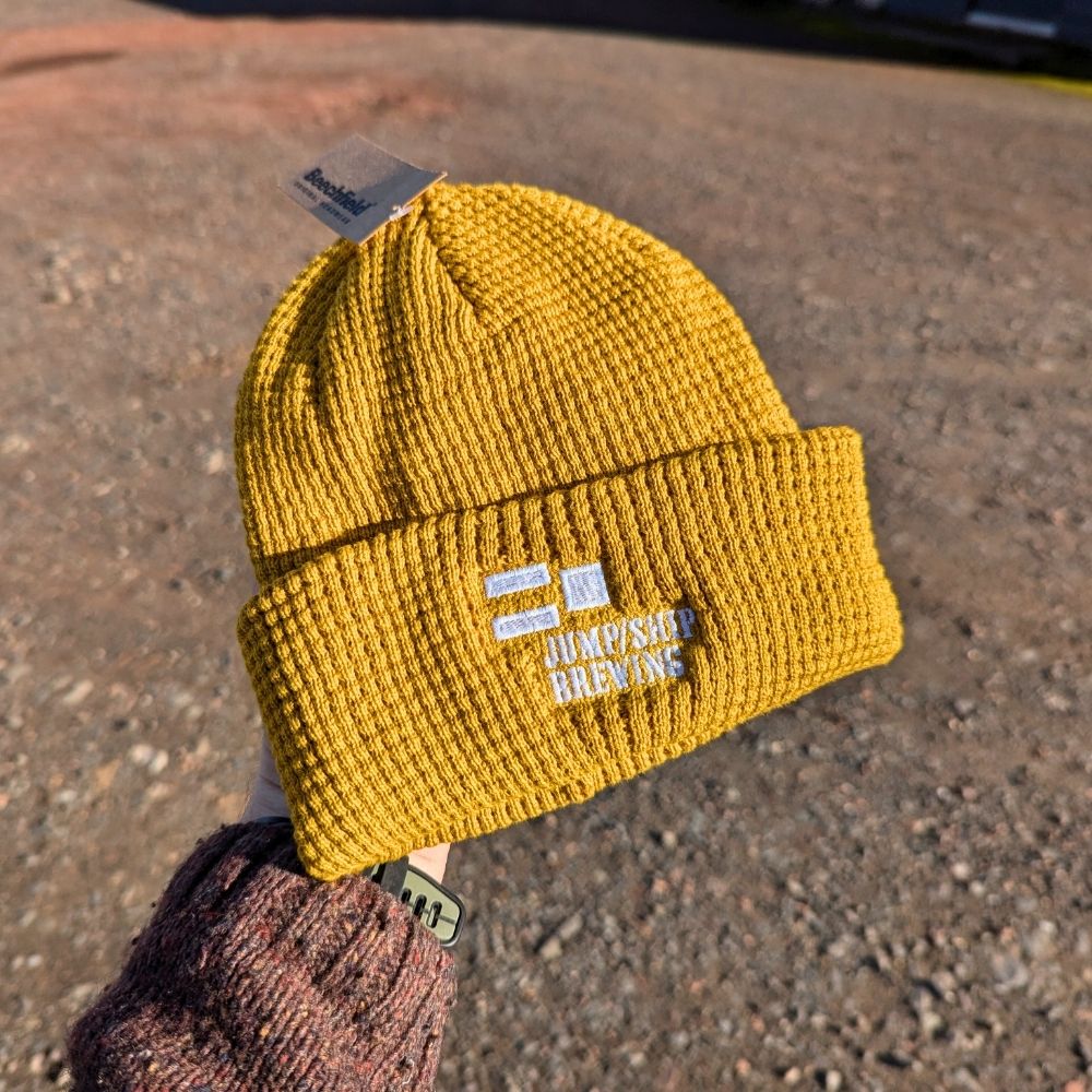 A mustard Jump Ship branded beanie
