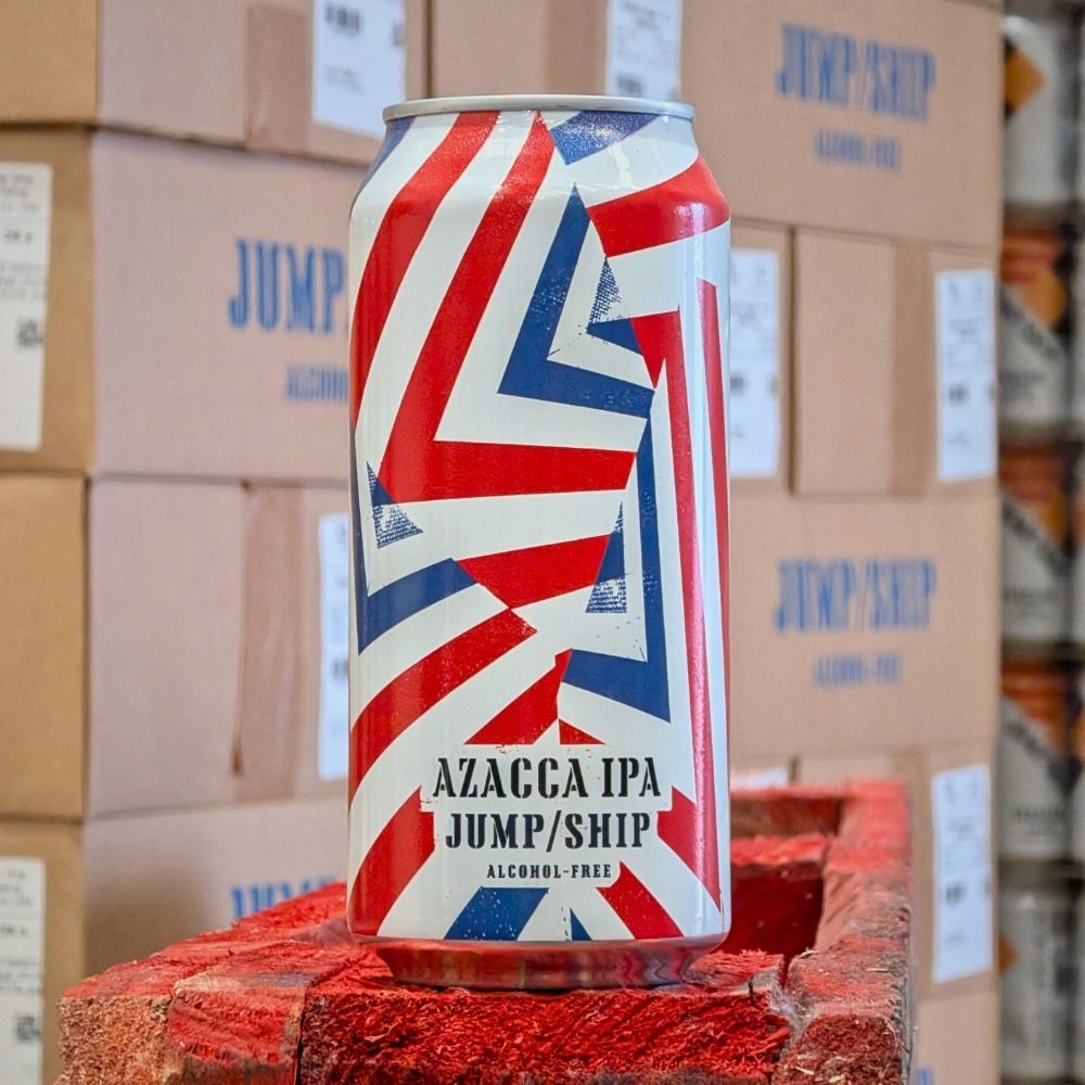 Can of AZACCA IPA with Dazzle camouflage design on a pallet, with cardboard boxes and 'JUMP/SHIP' branding in the background.
