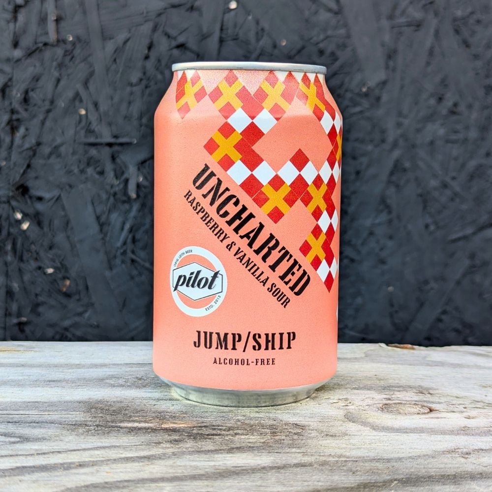 Pink can of 'Uncharted' raspberry & vanilla sour with checkered design on a wooden surface.