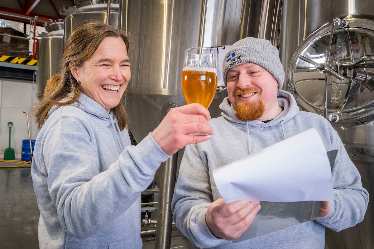 Sonja and Pete in an alcohol free brewery with a glass of alcohol-free beer