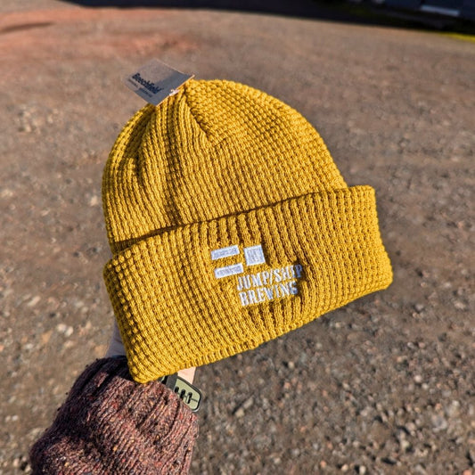 A mustard Jump Ship branded beanie