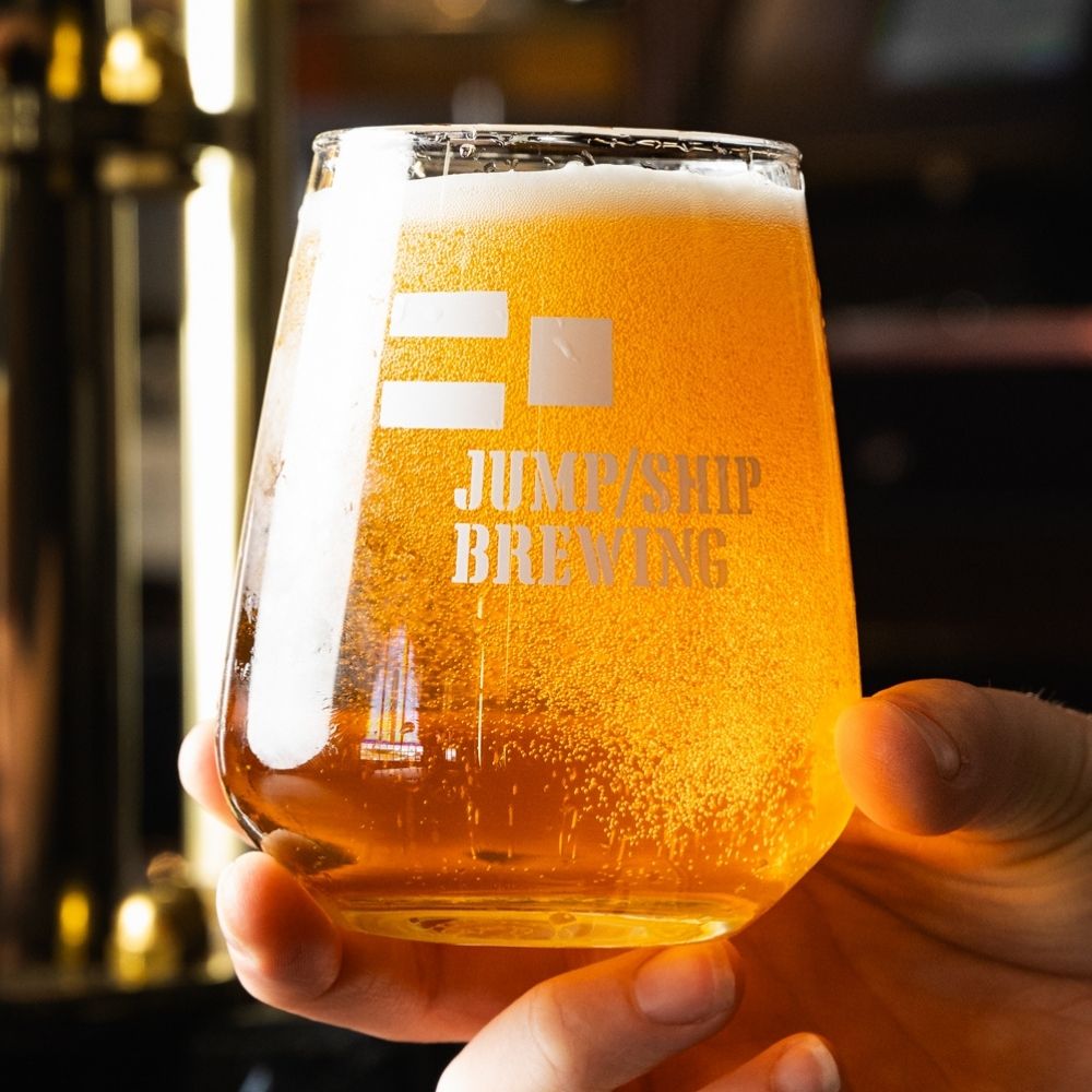 Glass of Yardarm from Jump/Ship Brewing held by a hand with a blurred background
